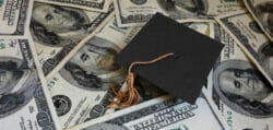 Graduation cap lays on top of money